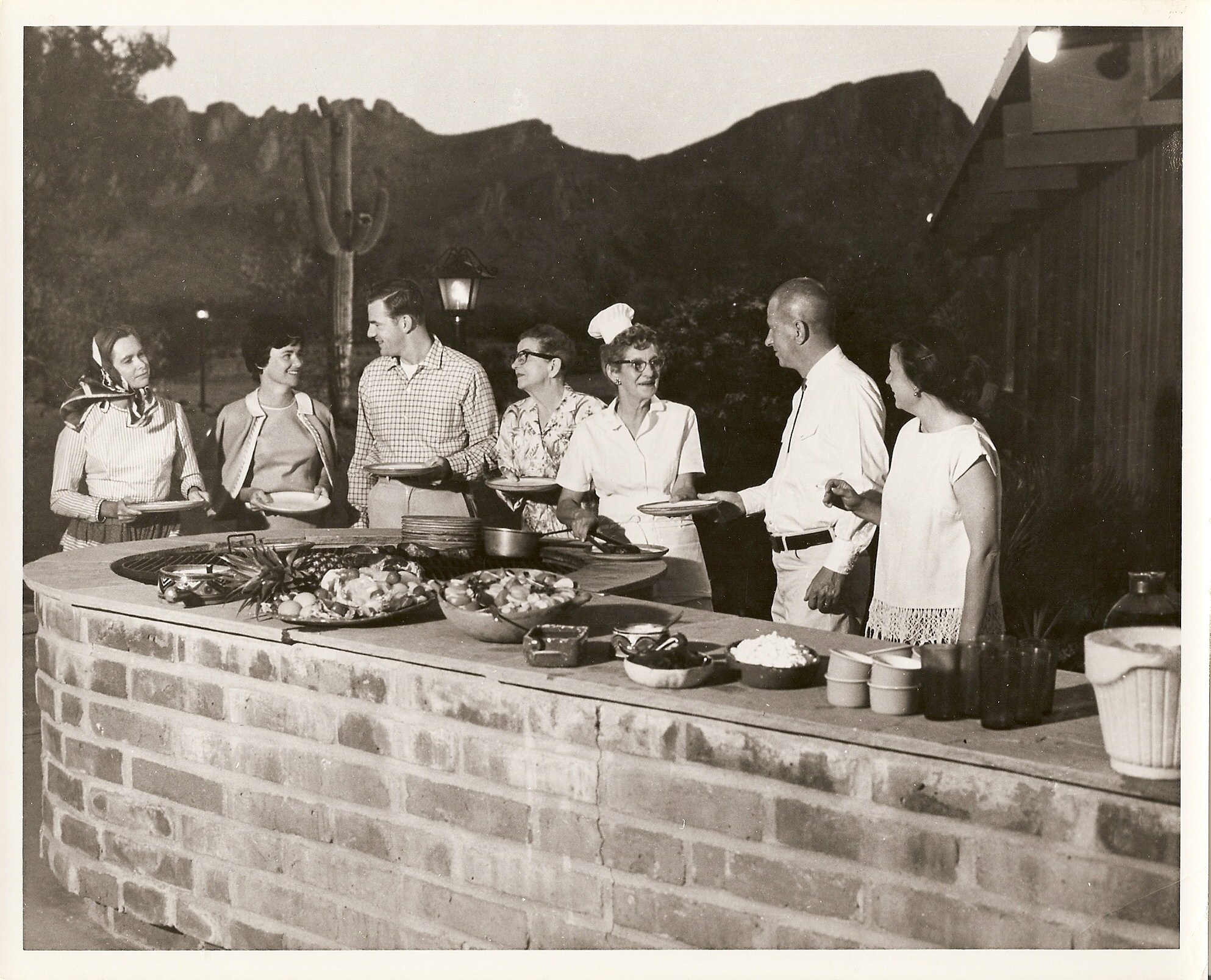a group of people standing around a barbecue