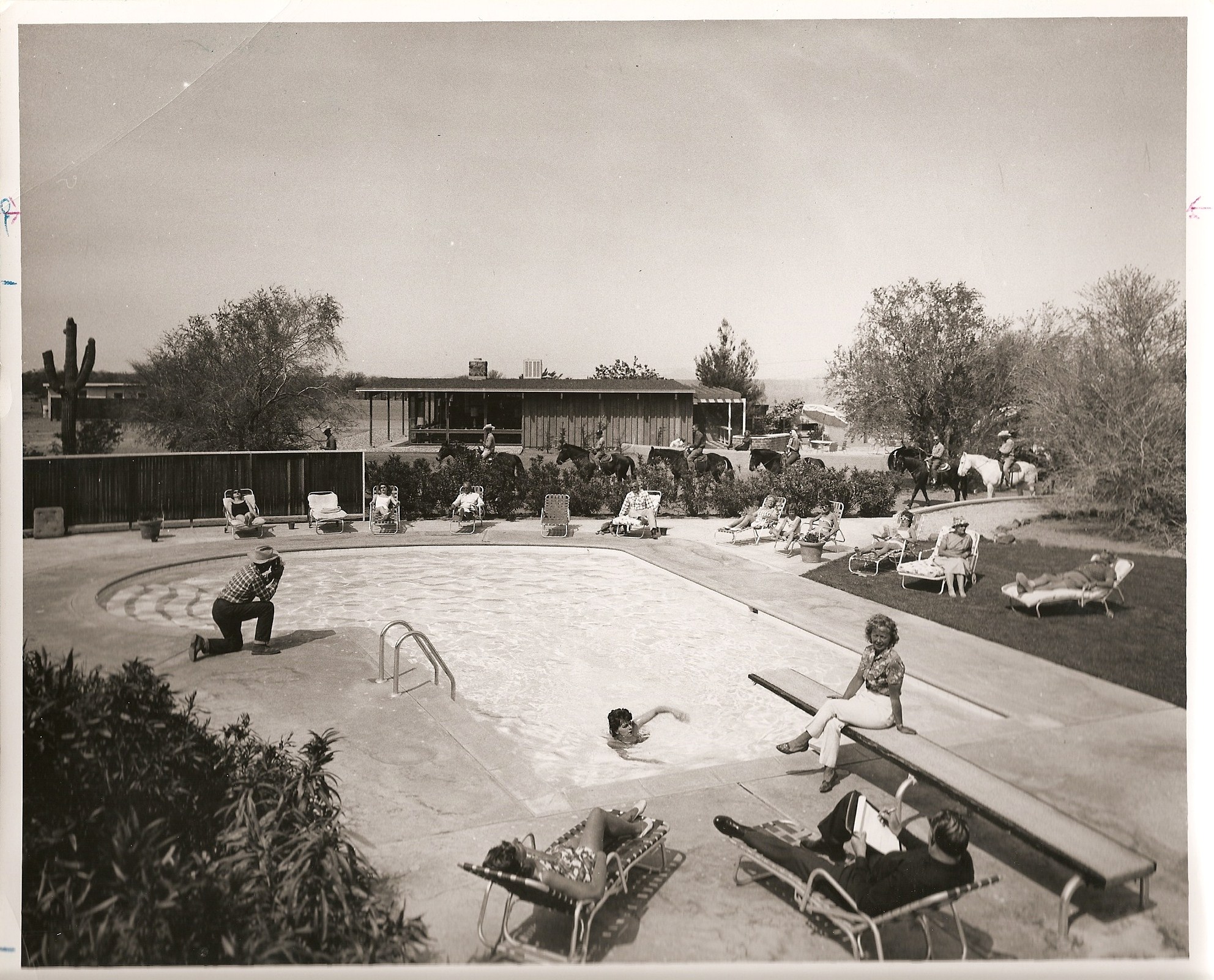 a pool with people sitting on lounge chairs