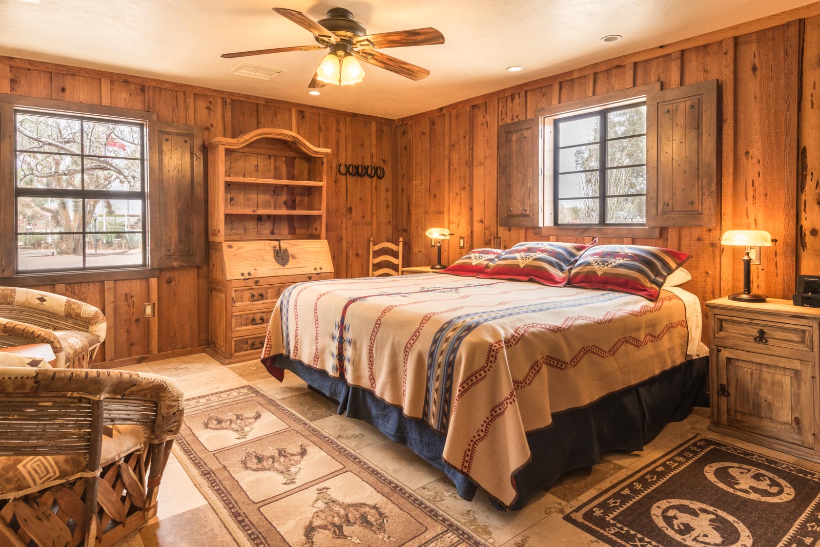 a bedroom with a large bed and a fan