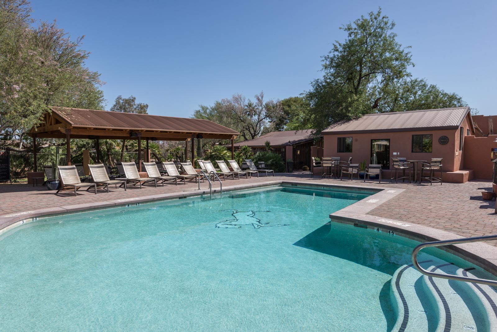 a pool with chairs and a gazebo