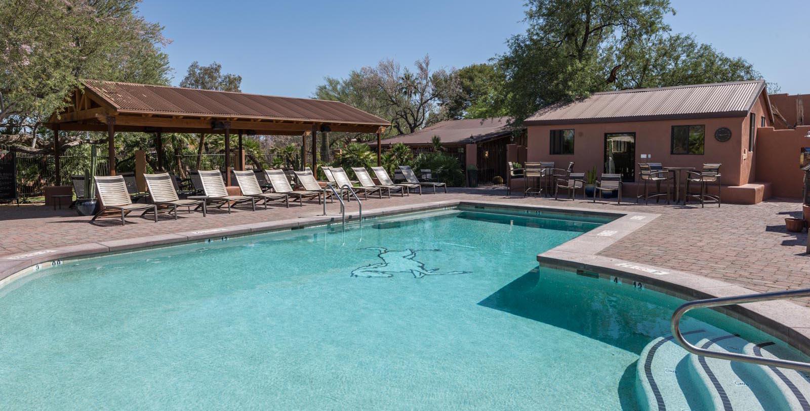 a pool with chairs and a gazebo