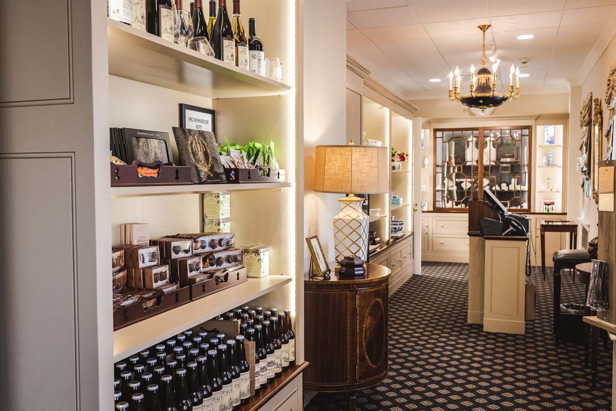 a room with shelves of liquor and a chandelier