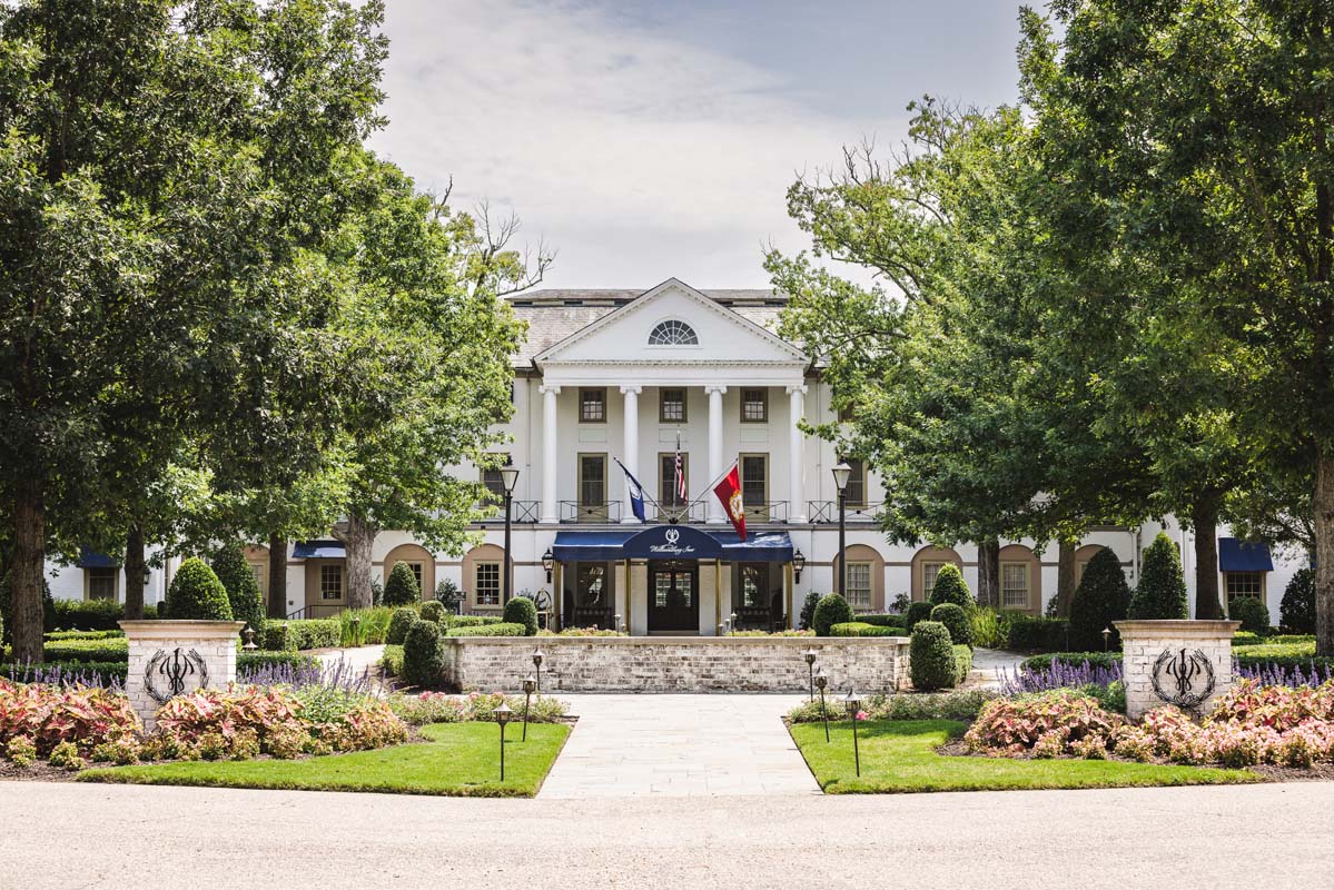 a white building with flags and trees