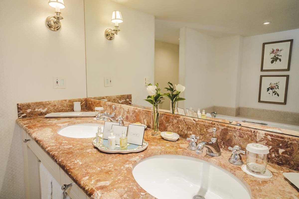 a bathroom with marble countertop sinks and a large mirror