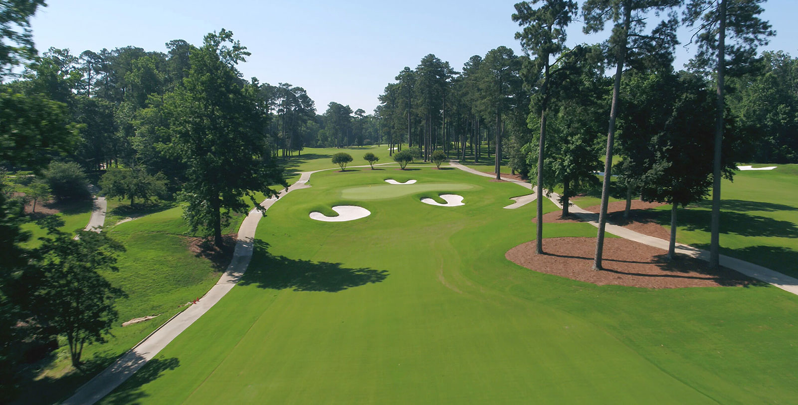 a golf course with trees and a path
