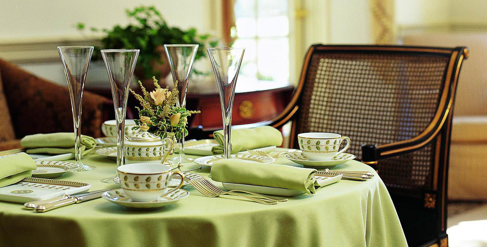 a table set with a green tablecloth and glasses