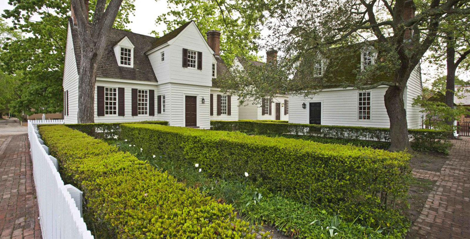 a house with a hedge and trees