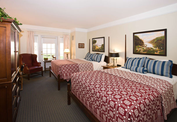 a room with two beds and a chair
