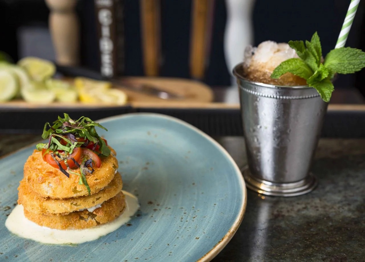 food on a plate next to a cup of ice