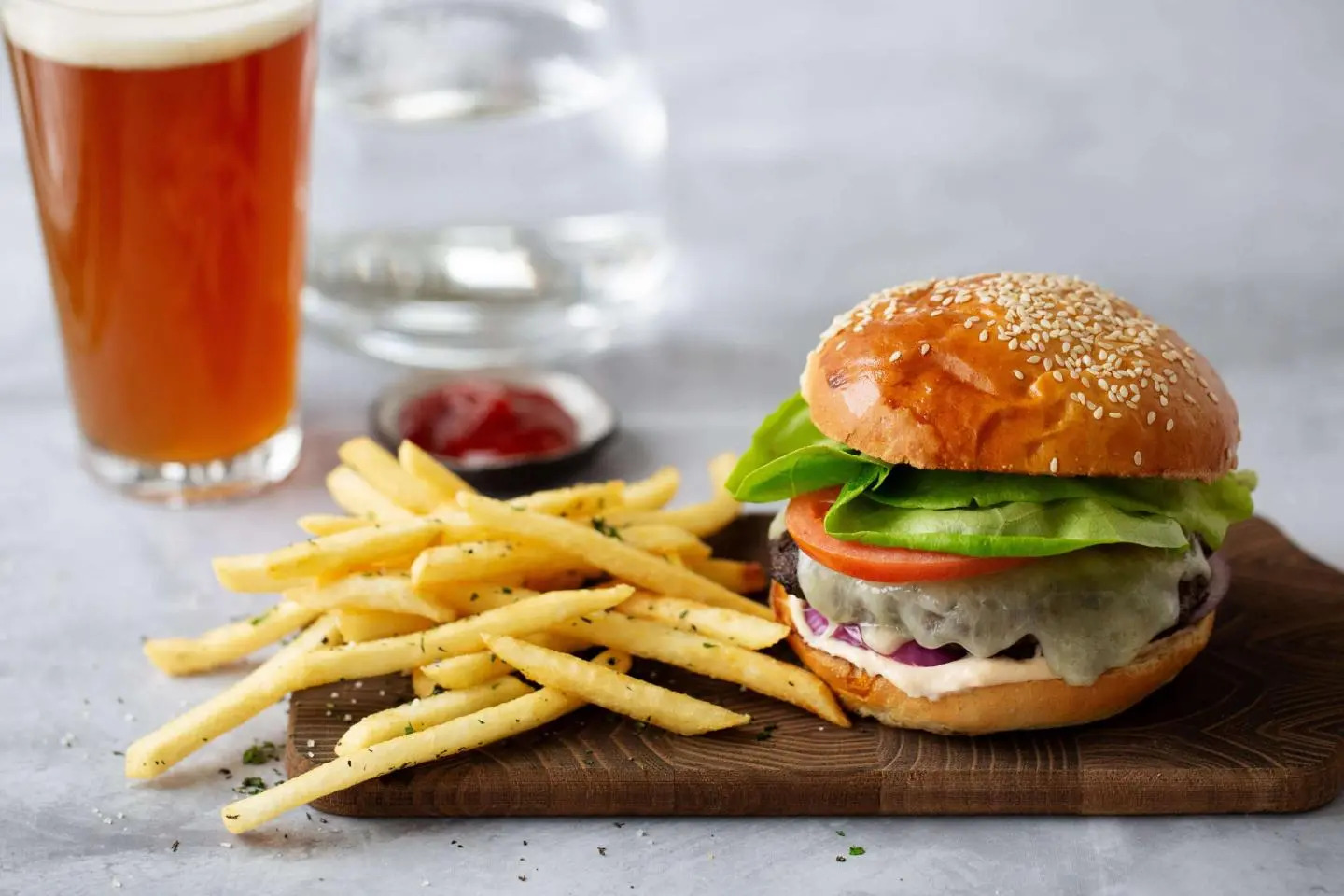 a burger and fries on a wooden board