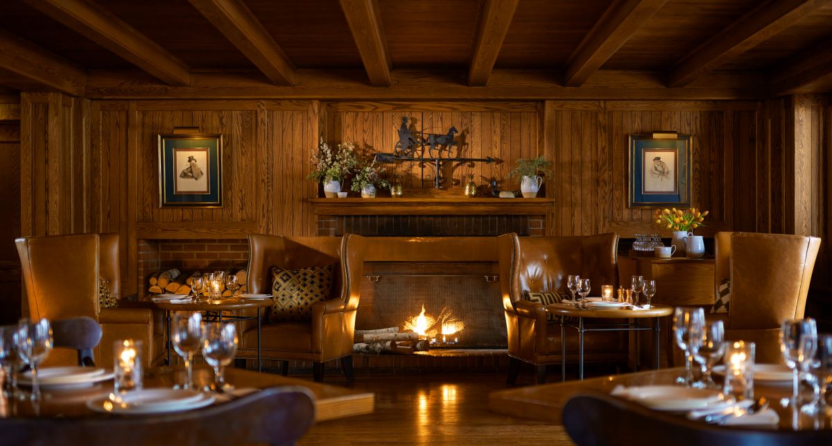 a room with a fireplace and tables and chairs