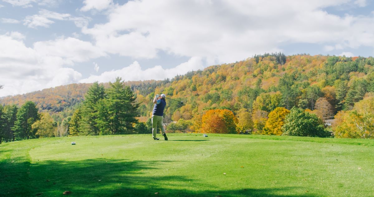 a man swinging a golf club on a golf course
