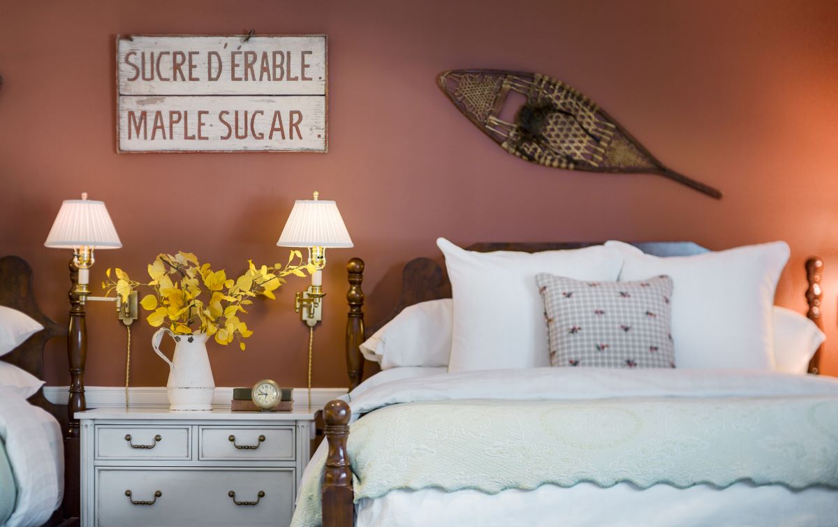 a bed with pillows and a lamp on a nightstand
