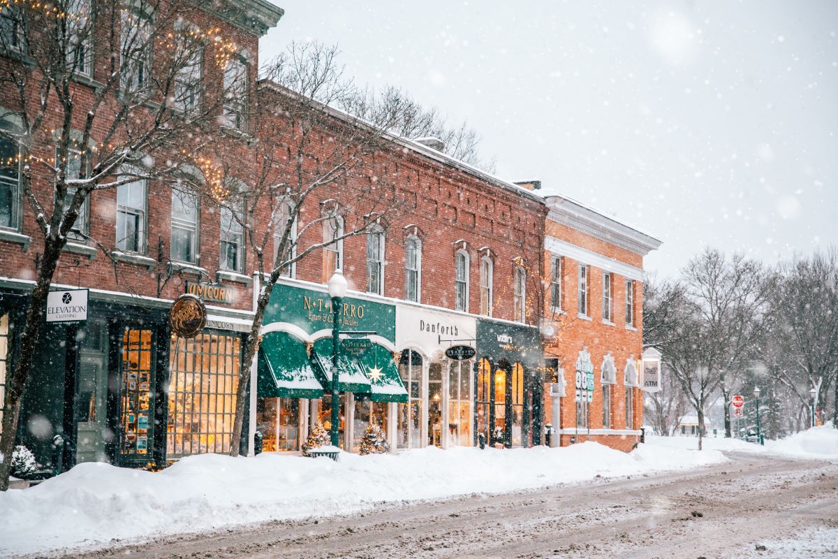 a snow covered street with shops and buildings