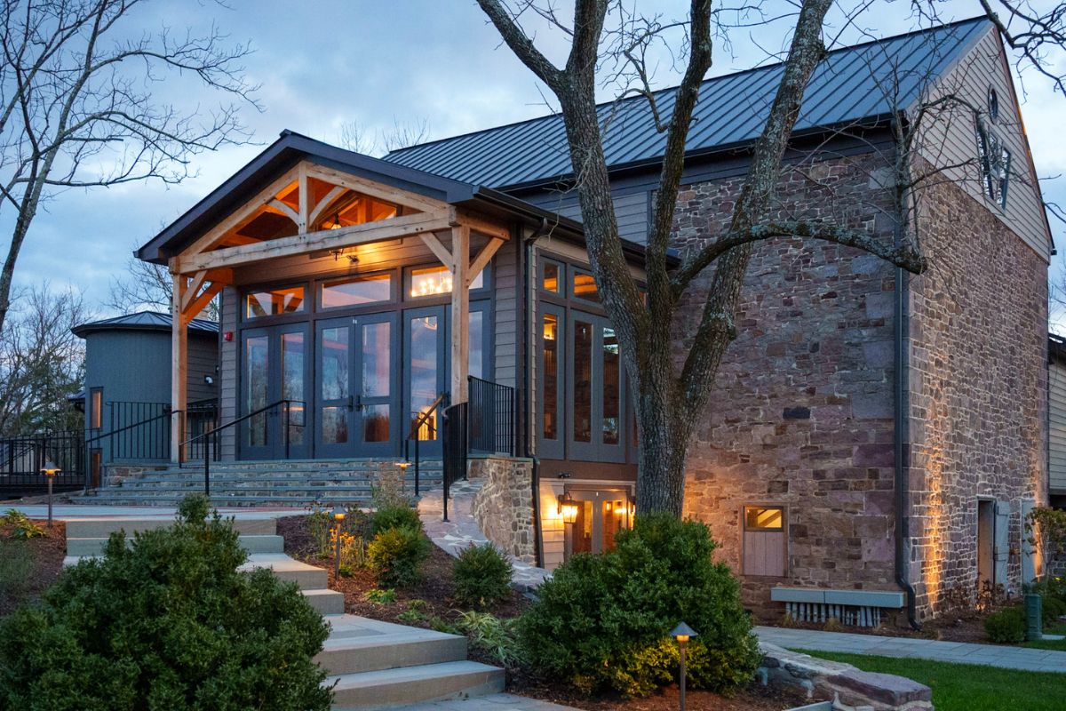 a building with a stone wall and a tree