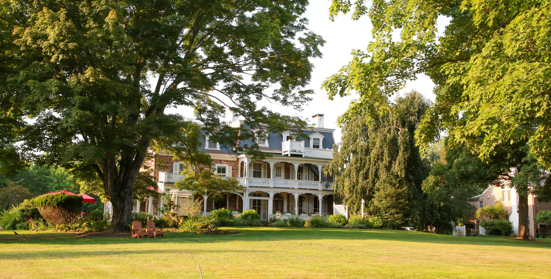 a large building with a lawn and trees
