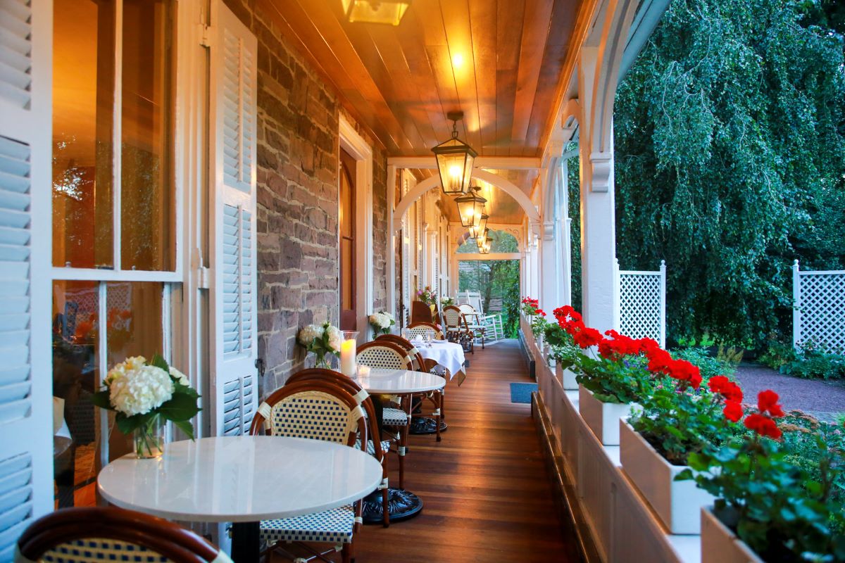 a porch with tables and chairs
