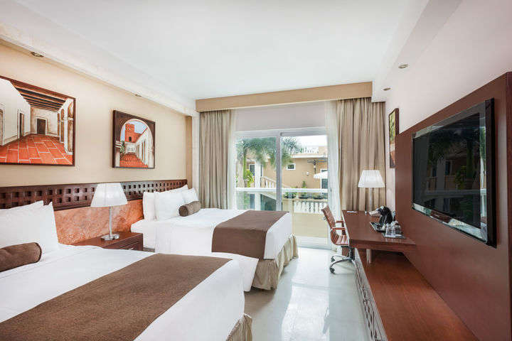 a room with two beds and a television