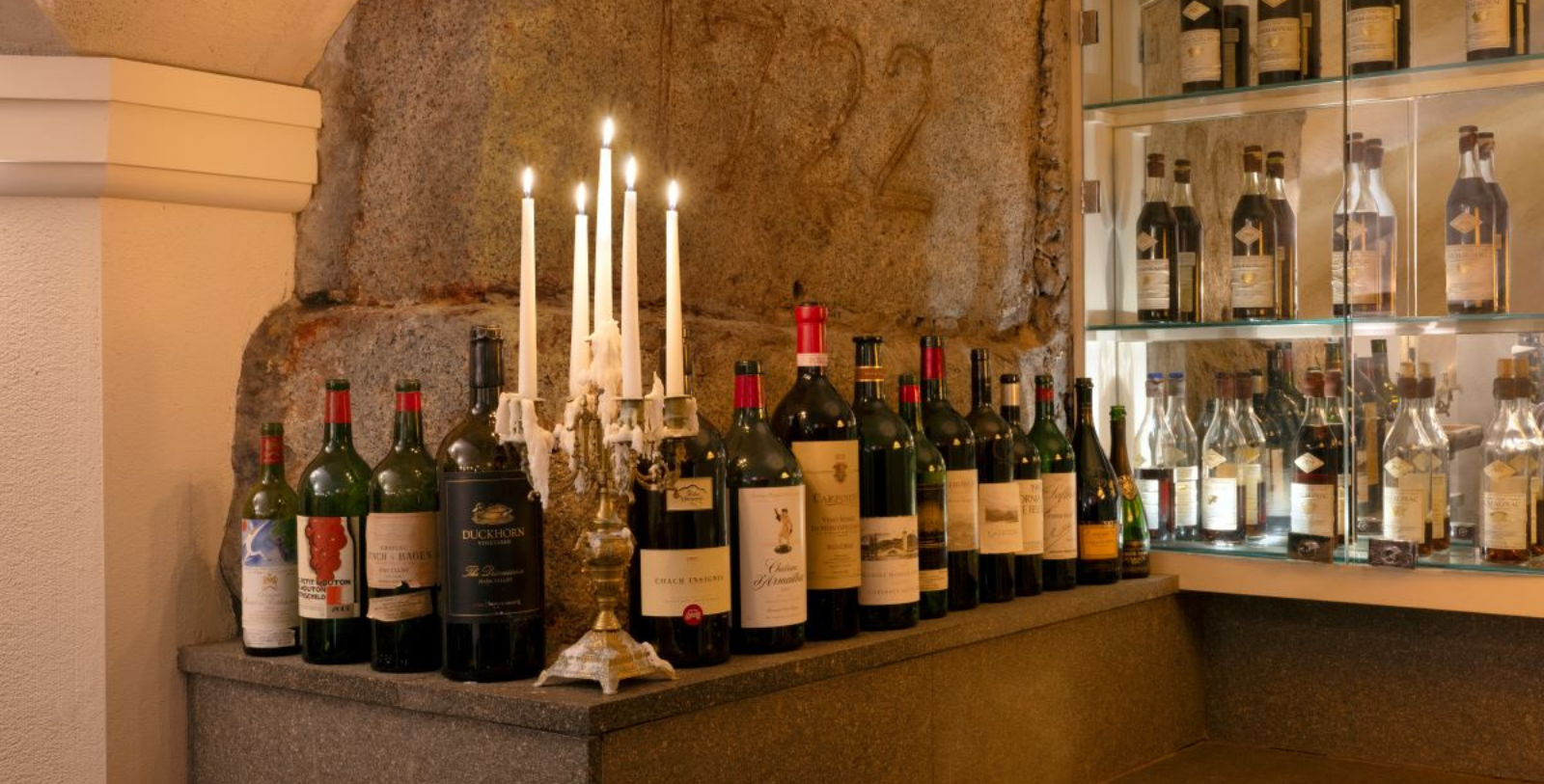 a group of wine bottles with candles