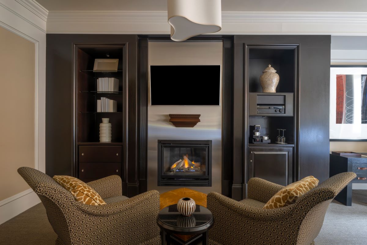 a living room with a fireplace and chairs